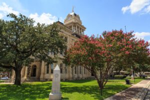 bell county courthouse with square, one of the best things to do in belton texas, with trees blooming pink flowers in the foreground