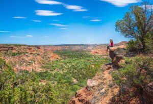 Kate Storm sitting on a ledge overlooking palo duro canyon near amarillo texas