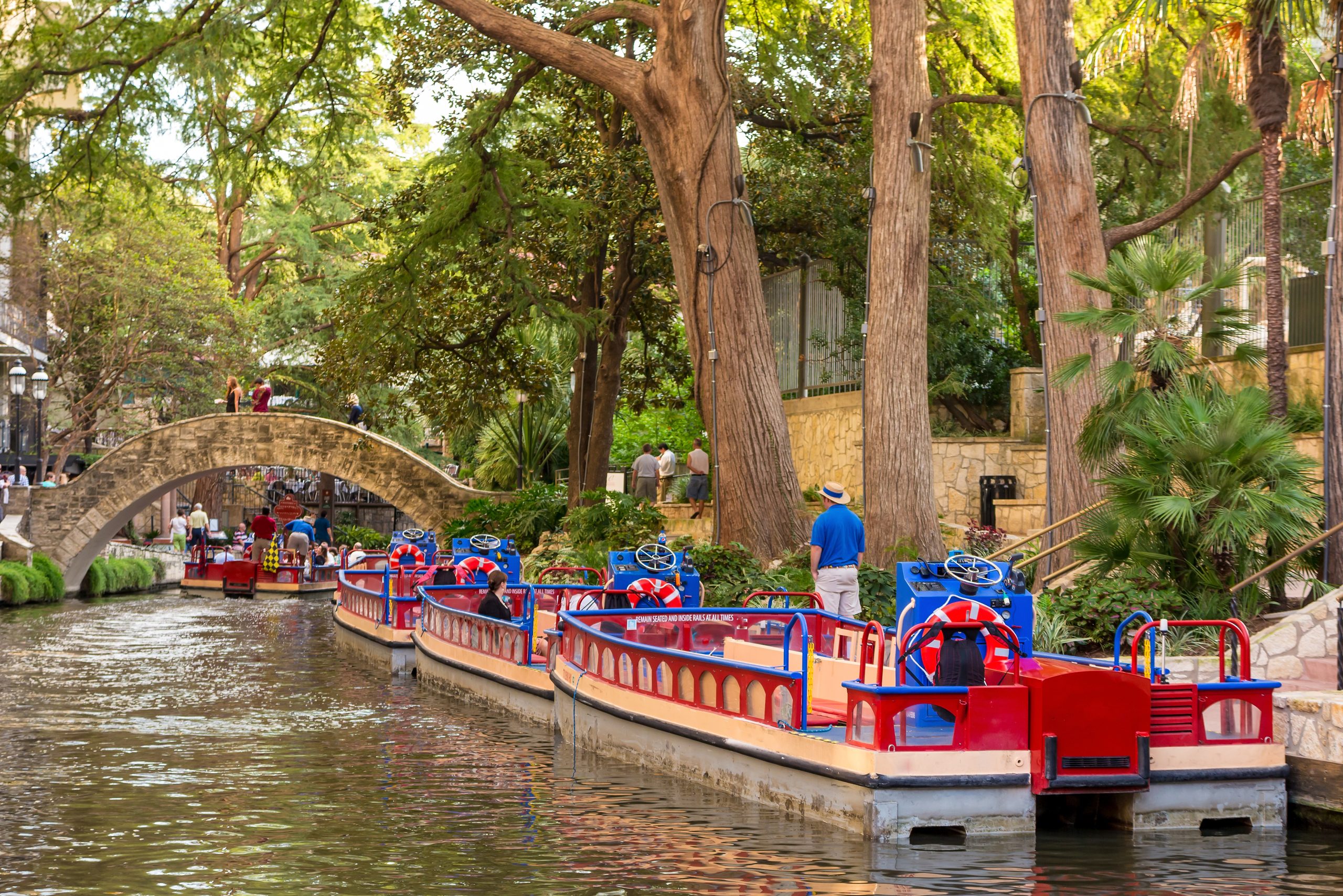Colorful tourist boats parked along the Riverwalk in San Antonio. The Riverwalk is one of the most instagrammable places in San Antonio