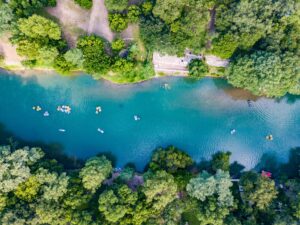 View of Guadalupe River from above with Texans floating on it. Guadalupe River State Park is one of the best day trips from San Antonio TX