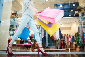 woman in jeans walking through a dallas mall with bags while shopping in dallas texas