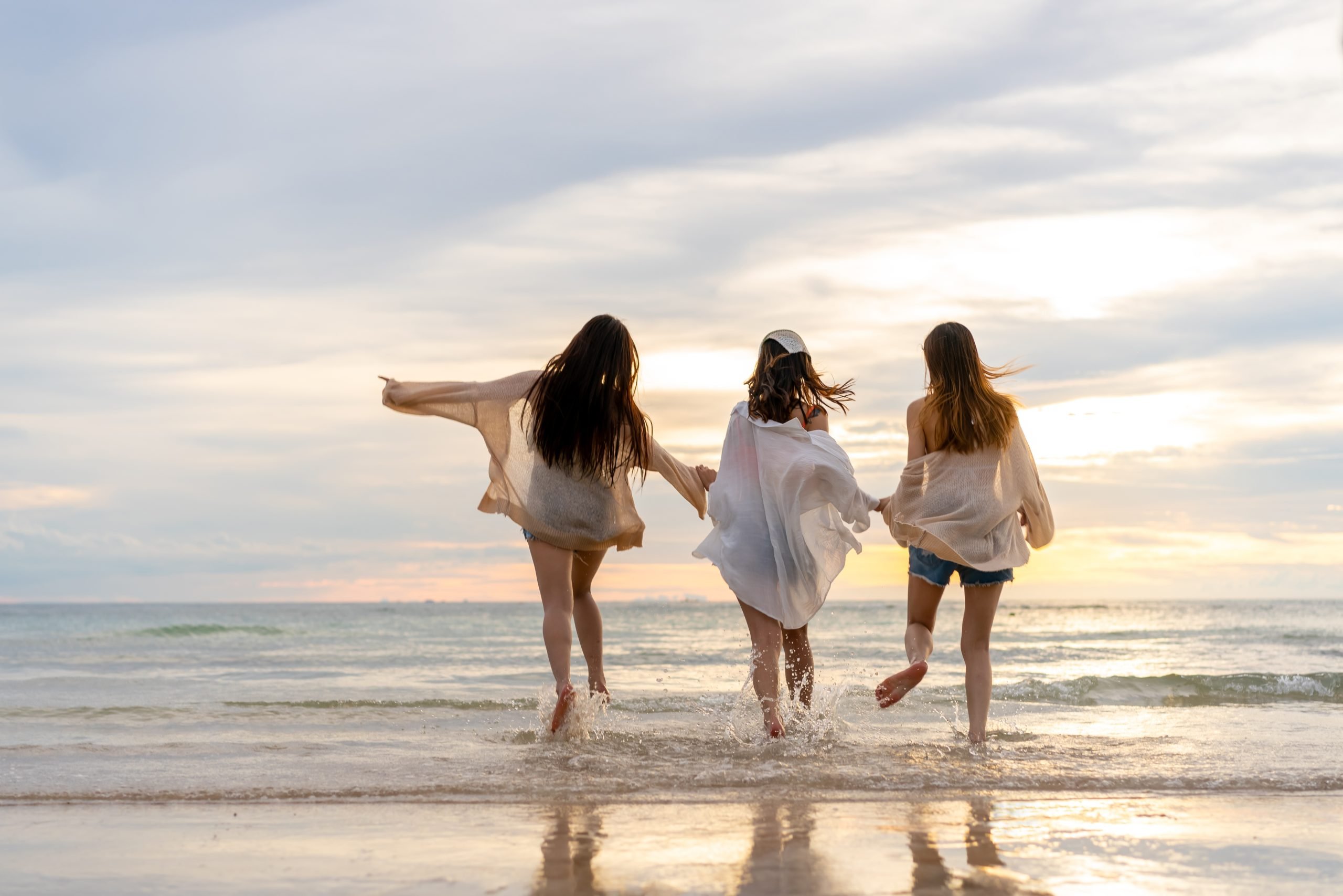 3 women walking on the beach at sunset during a girls trip in texas weekend